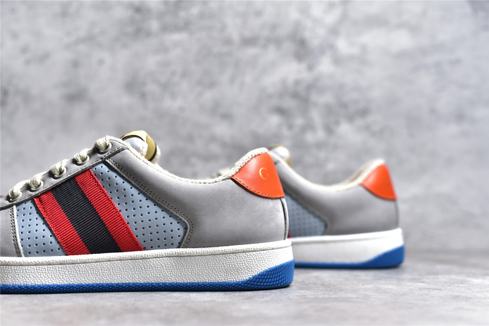 Gucci Screener series distressed sneakers, grey, blue, and orange colorway.